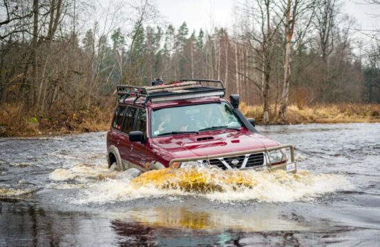 4x4 off-road vehicle driving through muddy forest trails in Sigulda Latvia adventure experience